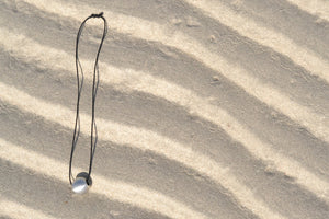 Peace bomb necklace on sand